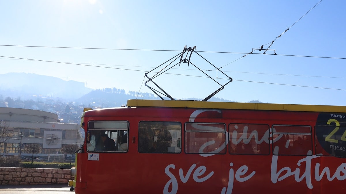 A red trolley car driving down a street